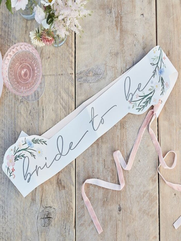 white floral paper sash has 'Bride to Be' written across the front