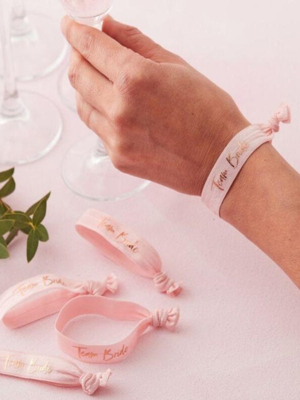 wristband is pink with rose gold team Bride text